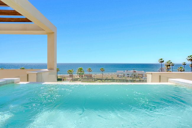 Luxurious south-facing four-bedroom duplex penthouse, frontline beach, located in a beachfront community on Marbella’s prestigious New Golden Mile with sea views.